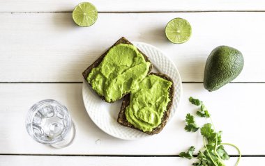 Beyaz ahşap arka plan üzerinde avokado ile Sandviçler.