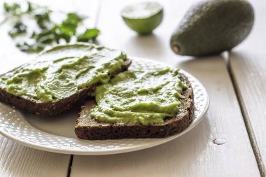 Beyaz ahşap arka plan üzerinde avokado ile Sandviçler.