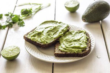 Beyaz ahşap arka plan üzerinde avokado ile Sandviçler.