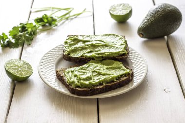 Beyaz ahşap arka plan üzerinde avokado ile Sandviçler.