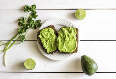 Beyaz ahşap arka plan üzerinde avokado ile Sandviçler.