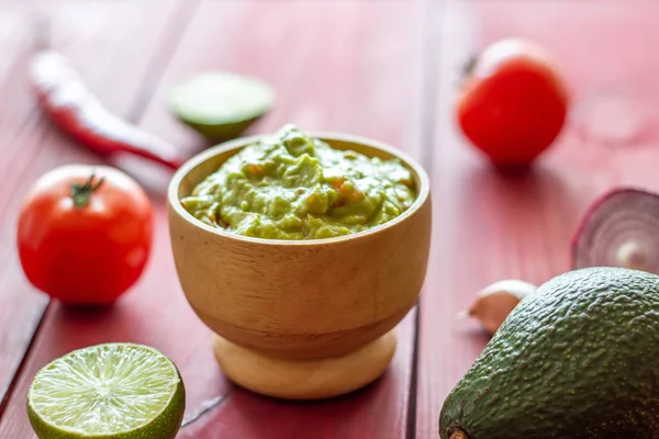 Guacamole e ingredientes. Fundo vermelho. Cozinha mexicana . — Fotografia de Stock