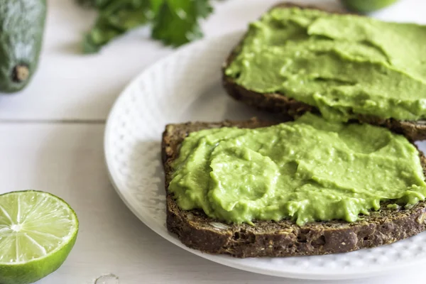 Sandwichs à l'avocat sur fond de bois blanc . — Photo