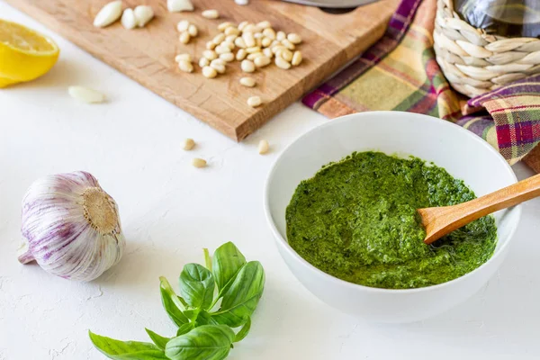 Molho de pesto e ingerentes em um fundo branco. Cozinha italiana. Comida vegetariana. A dieta . — Fotografia de Stock