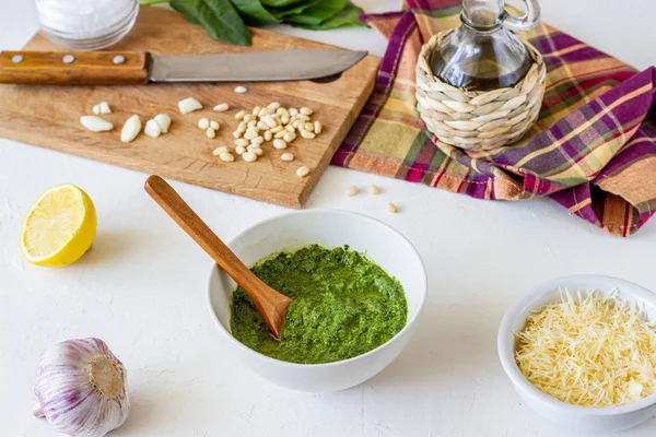 Molho de pesto e ingerentes em um fundo branco. Cozinha italiana. Comida vegetariana. A dieta . — Fotografia de Stock