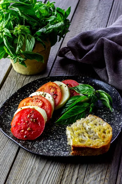 Włoska Sałatka Caprese z mozzarellą i pomidorami. Drewniane tło. Zdrowa żywność. — Zdjęcie stockowe
