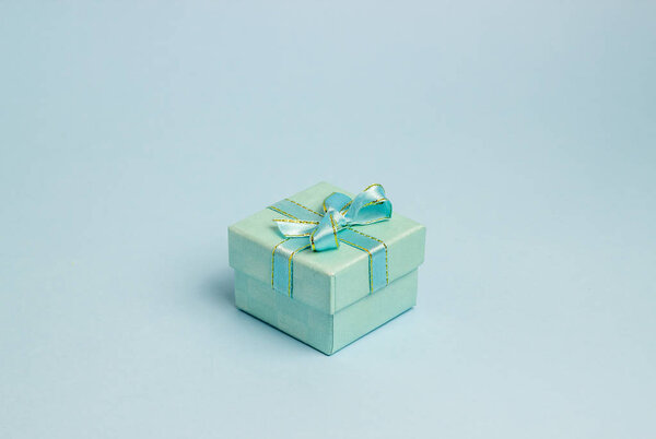 Подарочная коробка на синем фоне. Идея для открытки. Минимализм
