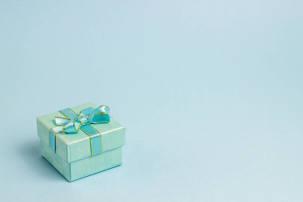 Подарочная коробка на синем фоне. Идея для открытки. Минимализм
