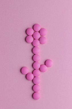 Pembe arka planda haplardan yapılmış bir çiçek. Sağlığa. İlaçlar. Eczane