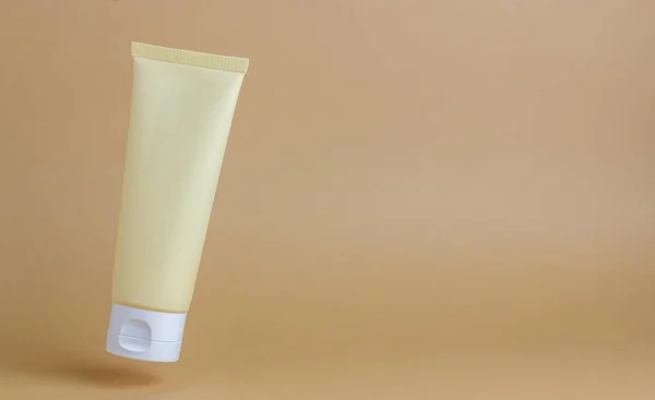 Cosmetic cream in a tube on a beige background. Natural cosmetics. Skincare. Mock-up. Copy space.