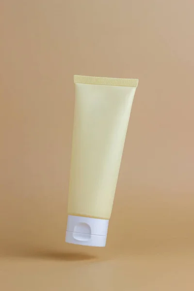 Bej arka planda bir tüpte kozmetik krem. Doğal kozmetikler. Cilt bakımı. Model-up. Boşluğu kopyala.
