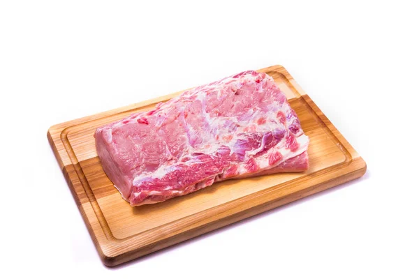 Rohes Schweinefleisch auf einem Holzbrett — Stockfoto