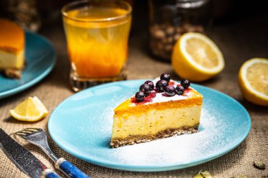 Mavi plaka üzerinde cheesecake dilim. Şeker kar.