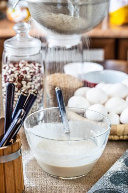 Un bir elekten inceleyip cam bir kase süte elenir..