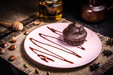 Bir restoranda pembe tabakta çikolatalı kek.