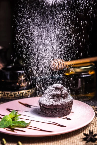 Restoranda pembe tabakta çikolatalı kek. Toz krema