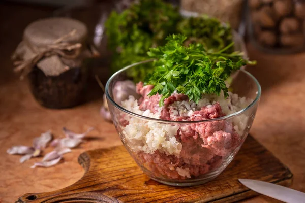 Minced meat with chopped onion and parsley in a glass plate. — Stock Photo, Image