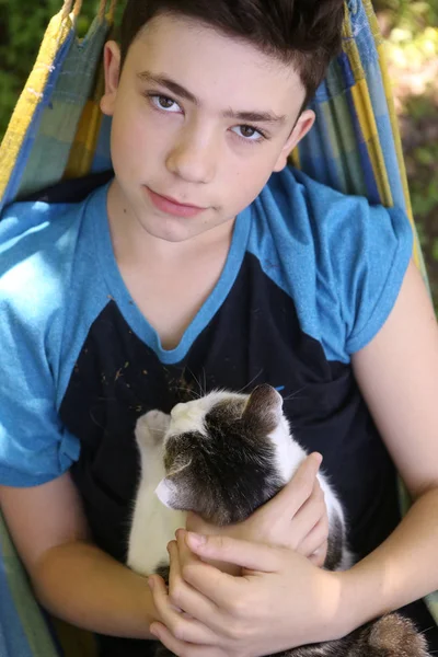 Adolescente menino com gato em hummock cochilo — Fotografia de Stock