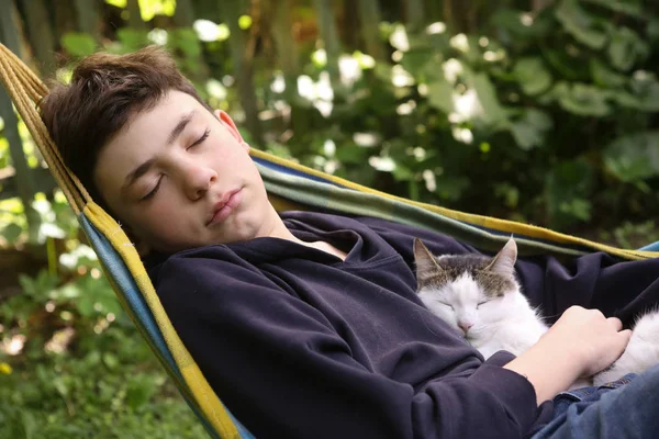 Adolescente chico con gato en hummock siesta — Foto de Stock