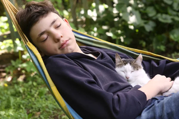 Adolescente chico con gato en hummock siesta — Foto de Stock