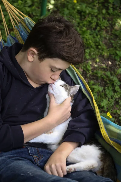 Teenager boy with cat in hummock nap — Stock Photo, Image