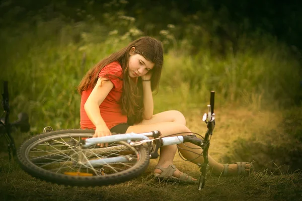 Teenager girl ride bicycle on country road through the forest — Stock Photo, Image