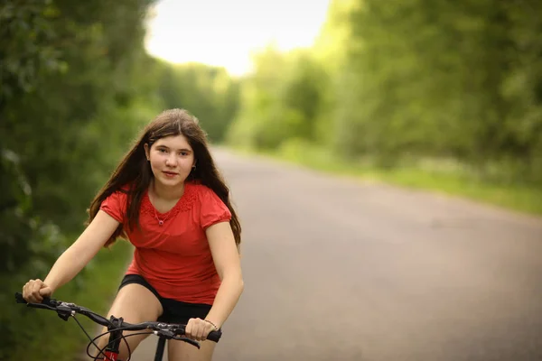 Tiener meisje fietstocht op landweg door het bos — Stockfoto