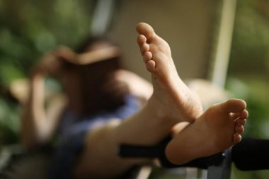 çıplak ayak fotoğrafını ekrana kız okuma kitabı ile kapatın.