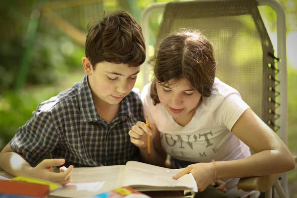 Tiener kinderen broers en zussen zus haar broer helpen met huiswerk taak — Stockfoto