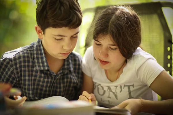 Genç çocuklar kardeş kardeşi ev ödevi görevi ile yardım — Stok fotoğraf