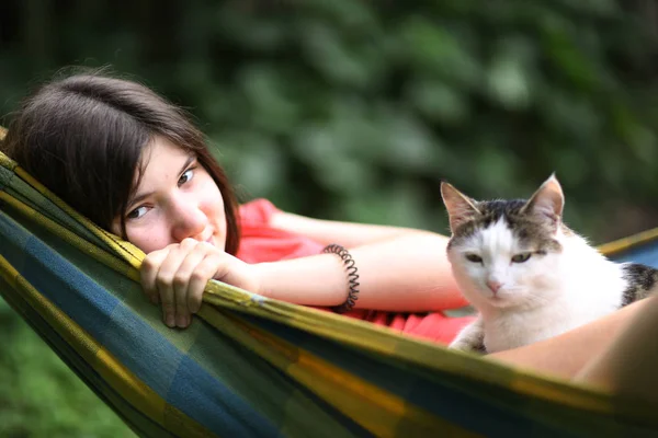 夏日阳光明媚的女孩在吊床拥抱猫特写户外照片 — 图库照片