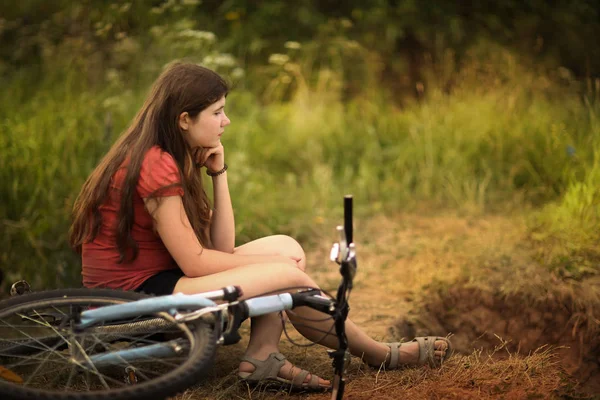 Adolescente menina passeio de bicicleta na estrada rural através da floresta — Fotografia de Stock