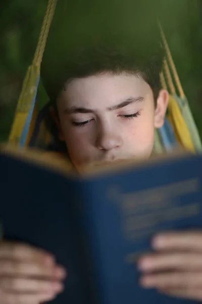 Teenager boy reading in hammock — Stock Photo, Image