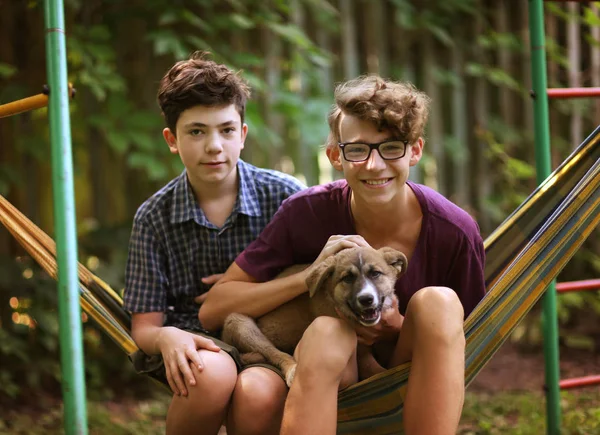 Tiener jongens in hangmat glimlachend gelukkig portret op groene tuin achtergrond — Stockfoto