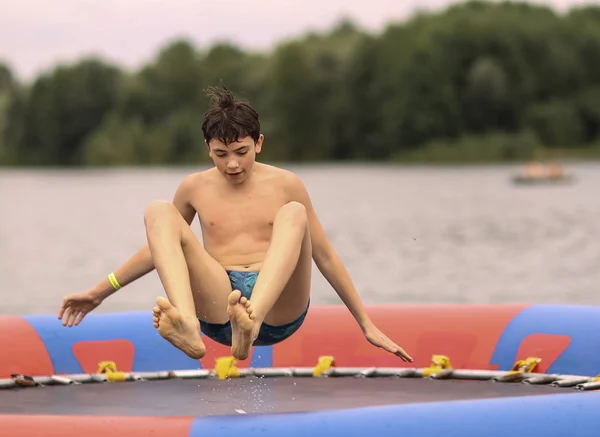 Chłopiec Nastolatek Otwartym Powietrzu Park Wodny Skok Trampolinie Bliska Zdjęcie — Zdjęcie stockowe