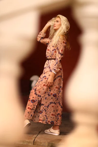 Beautiful blond tourist woman with sun glasses in floral print dress — Stock Photo, Image