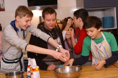 Moscow, Russia, November 21, 2017: Unidentified teenager kids cooking pasta on culinary master class - happy event, devoted to the end of school semester in Moscow. clipart