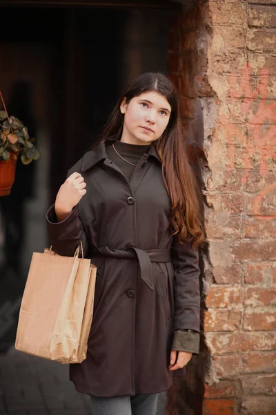 ティーンエイ ジャーの女の子市利用できる背景にショッピング バッグを使って長い茶色の髪通り写真付き — ストック写真