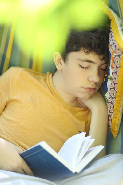 Adolescente niño descansando dormir con libro en hamaca en verano verde —  Fotos de Stock