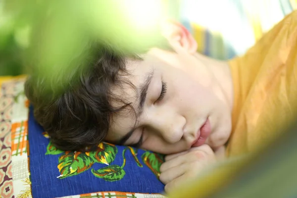 Adolescente menino descansando dormir com livro em rede no verão verde — Fotografia de Stock