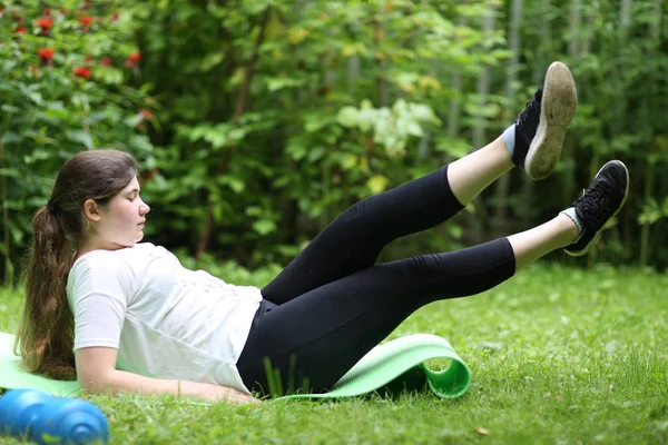 Teenager girl lay exhausted on gym rag with dumbbell after train — Stock Photo, Image