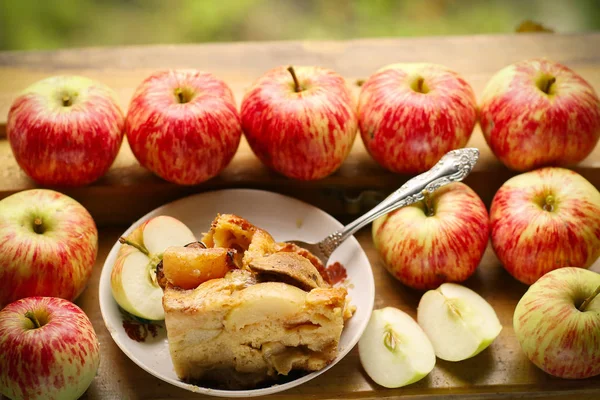 Stücke frisch gebackenen Apfelkuchens zwischen rohen Äpfeln Landhausstil s — Stockfoto