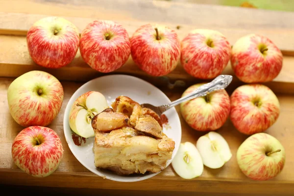 Pedaços de torta de maçã assada fresca entre maçãs cruas estilo country s — Fotografia de Stock