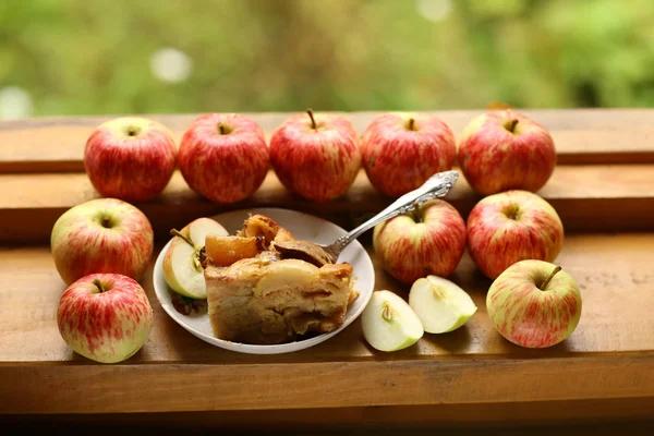 Trozos de pastel de manzana recién horneado entre manzanas crudas estilo país s —  Fotos de Stock