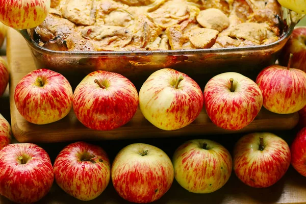 Kawałki świeżego pieczone jabłecznik wśród surowych jabłek stylu kraju s — Zdjęcie stockowe