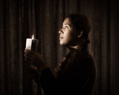 Mumlu genç bir kadının karanlık anahtar portresi. Yaklaş.