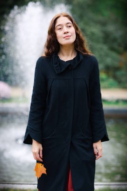 Romantik sonbahar, yapraklı bir kadının klasik portresi.