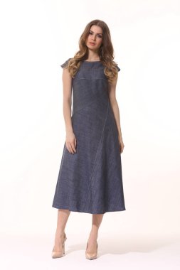 Kot pantolon ceketi ve uzun etek giyen bir iş kadını yöneticisi. 