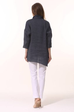 İş kadını yöneticisi, beyaz hırka ile poz veriyor. Beyaz pantolon, beyaz arka planda vücut boyu kadar izole edilmiş.