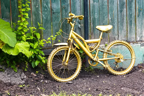 Złoty Rower Jako Formalna Dekoracja Ogrodu Drewnianym Niebieskim Tle Ogrodzenia — Zdjęcie stockowe
